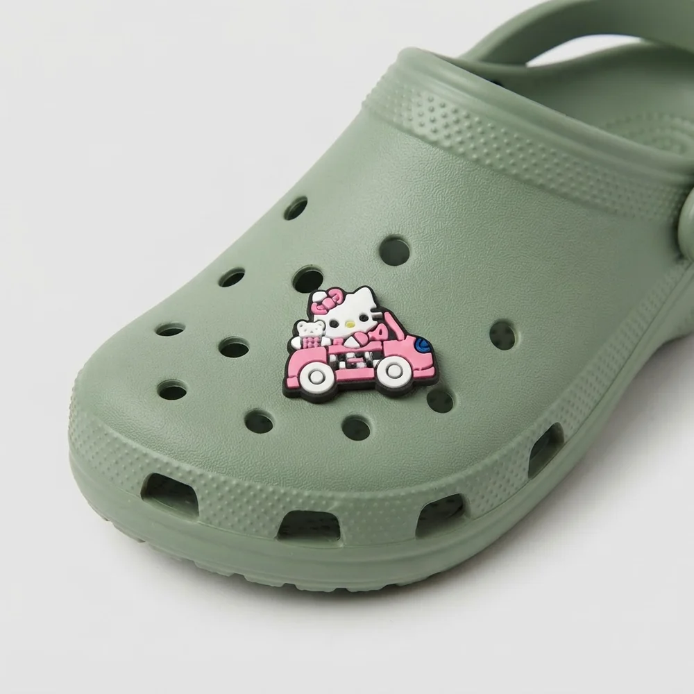 Jibbitz Hello Kitty en taxi rose sur une Crocs vert sauge